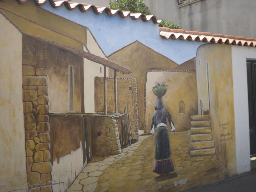 Murale donna con cestino nel vicolo Nuoro Sardegna